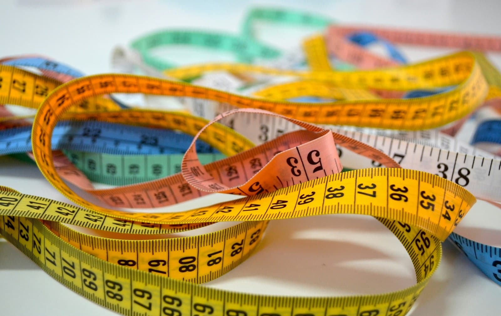 Colorful soft sewing tape measures tangled together